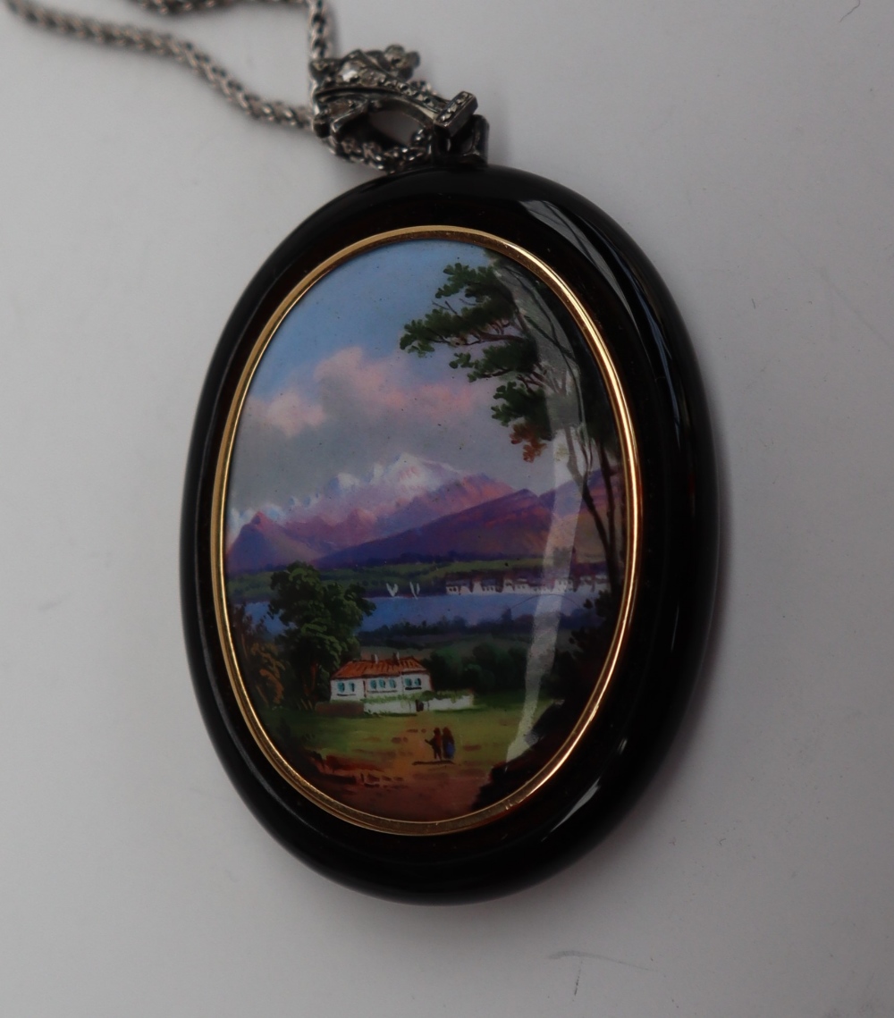 A continental pendant with an oval panel painted with a lake scene with a mountain range beyond, - Image 2 of 4