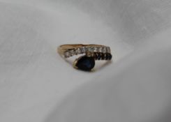 A sapphire and diamond ring, with a pear shaped sapphire and four round faceted sapphires,