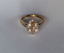 An Edwardian Diamond Dress ring set with round old cut diamonds to a white metal setting and yellow