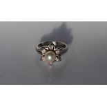 A pearl and diamond dress ring, the central raised pearl approximately 7mm in diameter,
