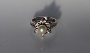 A pearl and diamond dress ring, the central raised pearl approximately 7mm in diameter,