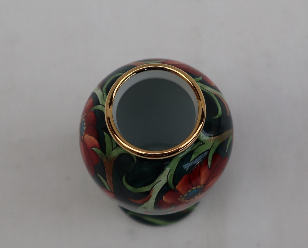 A Moorcroft enamels baluster vase, decorated with flowers and leaves to a green ground, - Image 5 of 5