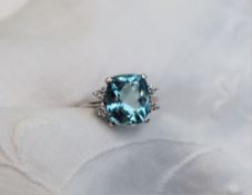 An aquamarine and diamond ring, the central cushion shaped aquamarine approximately 11 x 9mm,