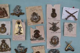 A collection of circa thirty two military cap badges including East Surrey, Duke of Lancasters Own,