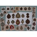 A collection of circa thirty five military cap badges including The Norfolk Regt,