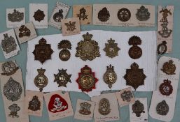 A collection of circa thirty five military cap badges including The Norfolk Regt,