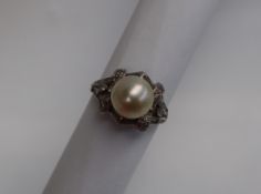 A pearl and diamond dress ring, the central pearl approximately 9mm,