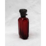 An Edwardian Silver topped and cranberry glass scent bottle, cast with leaves to a faceted body,