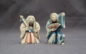 A pair of early 20th century Japanese carved ivory figures, with rotating heads,