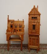 A modern bookcase in the form of a tudor house, with windows and door, enclosing three shelves,