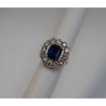 A sapphire and diamond cluster ring, the emerald cut sapphire approximately 11mm x 8mm,