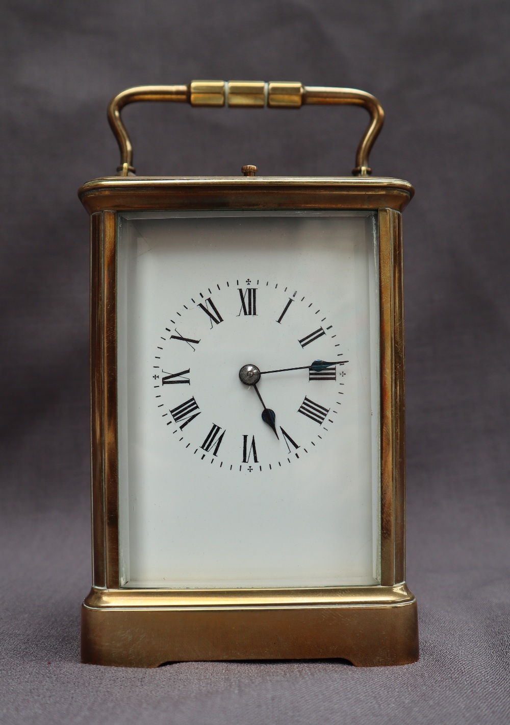 A French brass carriage clock, with a shaped handle and insight platform escapement,