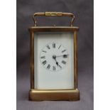 A French brass carriage clock, with a shaped handle and insight platform escapement,