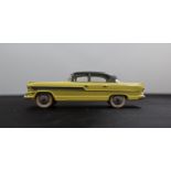 A Dinky Toys diecast model of a Hudson Hornet Sedan, with a yellow body, grey roof and side flashes,