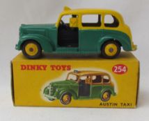 A Dinky Toys diecast model of an Austin Taxi, with a green lower body, yellow upper body,