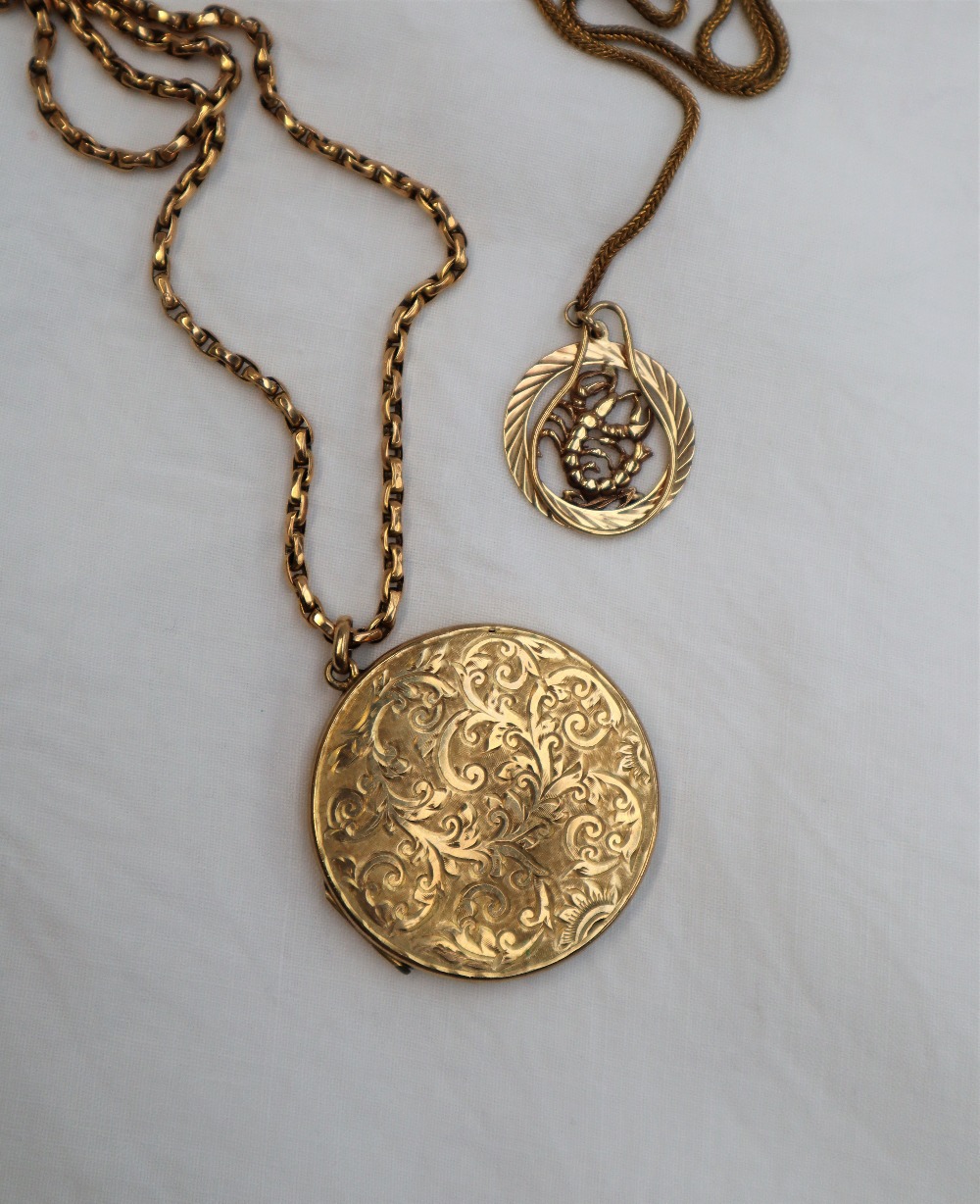 A 9ct yellow gold locket of circular form,