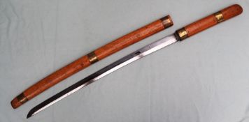 A Japanese sword, with a wooden scabbard and handle, with brass mounts with a 60cm curved blade,
