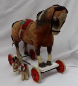 A Steiff pull along horse with well loved mohair body on white rimmed red wheels,