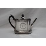 A Victorian silver teapot of rectangular form, decorated with bands of flowers and a straight spout,