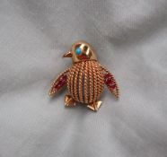 An 18ct yellow gold brooch in the form of a penguin, the eye set with a turquoise,