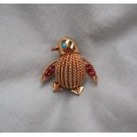 An 18ct yellow gold brooch in the form of a penguin, the eye set with a turquoise,