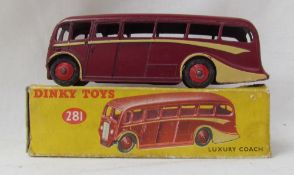 A Dinky Toys diecast model of a Luxury Coach, with a burgundy body, cream coach lines and red hubs,