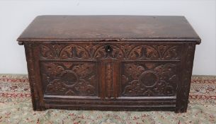 An 18th century oak coffer, the moulded top above a carved two panel front on stiles, 101.