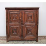 A late 17th century oak side cupboard, the moulded cornice above two moulded panel doors,