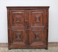 A late 17th century oak side cupboard, the moulded cornice above two moulded panel doors,