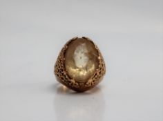 A citrine set dress ring, the oval faceted citrine to a yellow metal setting and shank,