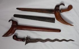 An Indonesian Kris dagger, with an olivewood hilt and scabbard with a chased white metal scabbard,