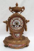 A 19th century French gilt bronze mantle clock, with a twin handled vase surmount,