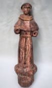 A carved pine figure of a monk, with traces of gesso and paint residue,