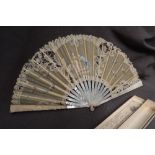 A mother of pearl, bone and lace fan, decorated with a courting couple and floral swags, 24.