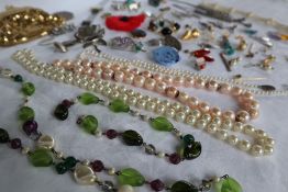 Assorted costume jewellery including a faux pearl necklace, bead necklaces, wristwatch,