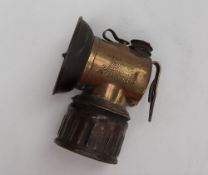 An early 20th century Justrite brass miners helmet lamp, with a 6.