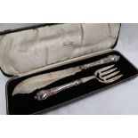A pair of Victorian silver fish knife and fork servers, engraved with fish and scrolling leaves,