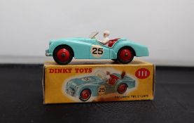 A Dinky Toys diecast model of a Triumph TR2, with a mint green body, red hubs,