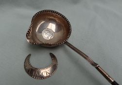 An 18th century white metal toddy ladle, with a beaded edge inset with a George II six pence,