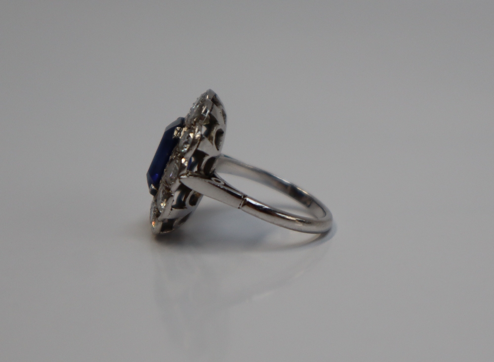 A sapphire and diamond cluster ring, the emerald cut sapphire approximately 11mm x 8mm, - Image 4 of 6