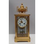 A 19th Century French four glass mantle clock, with a gilt metal vase surmount, on a marble plinth,