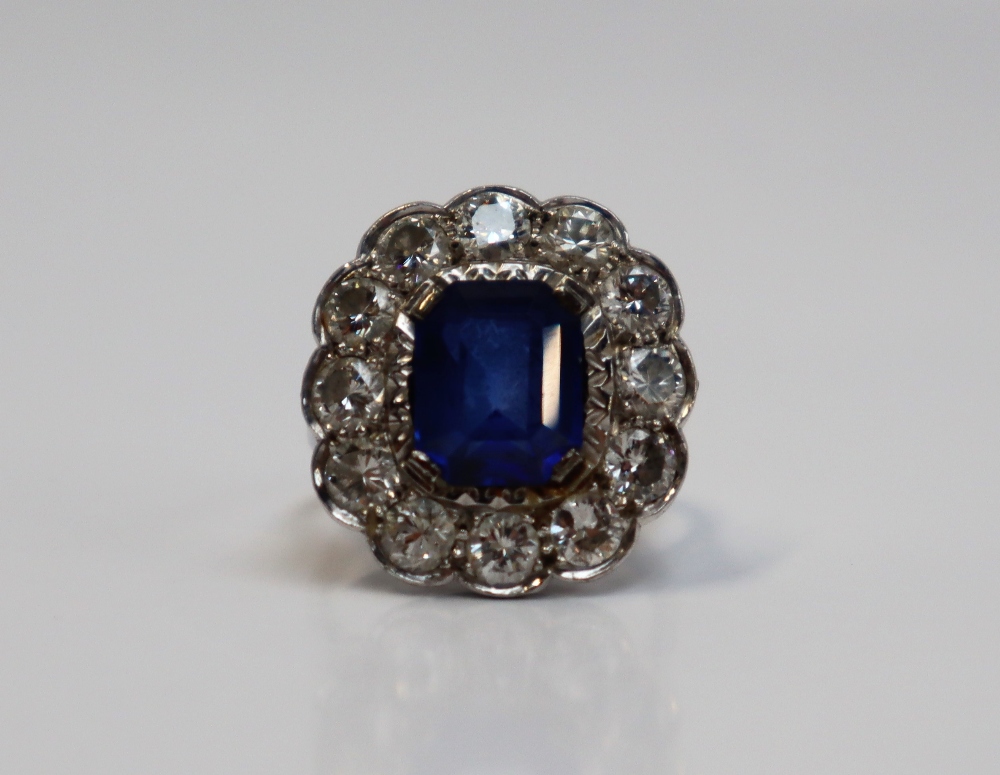 A sapphire and diamond cluster ring, the emerald cut sapphire approximately 11mm x 8mm, - Image 3 of 6