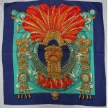 A Hermes silk scarf, decorated with a feather headdress and idol, South American inspired design,