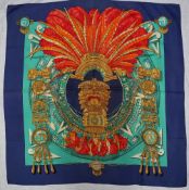 A Hermes silk scarf, decorated with a feather headdress and idol, South American inspired design,