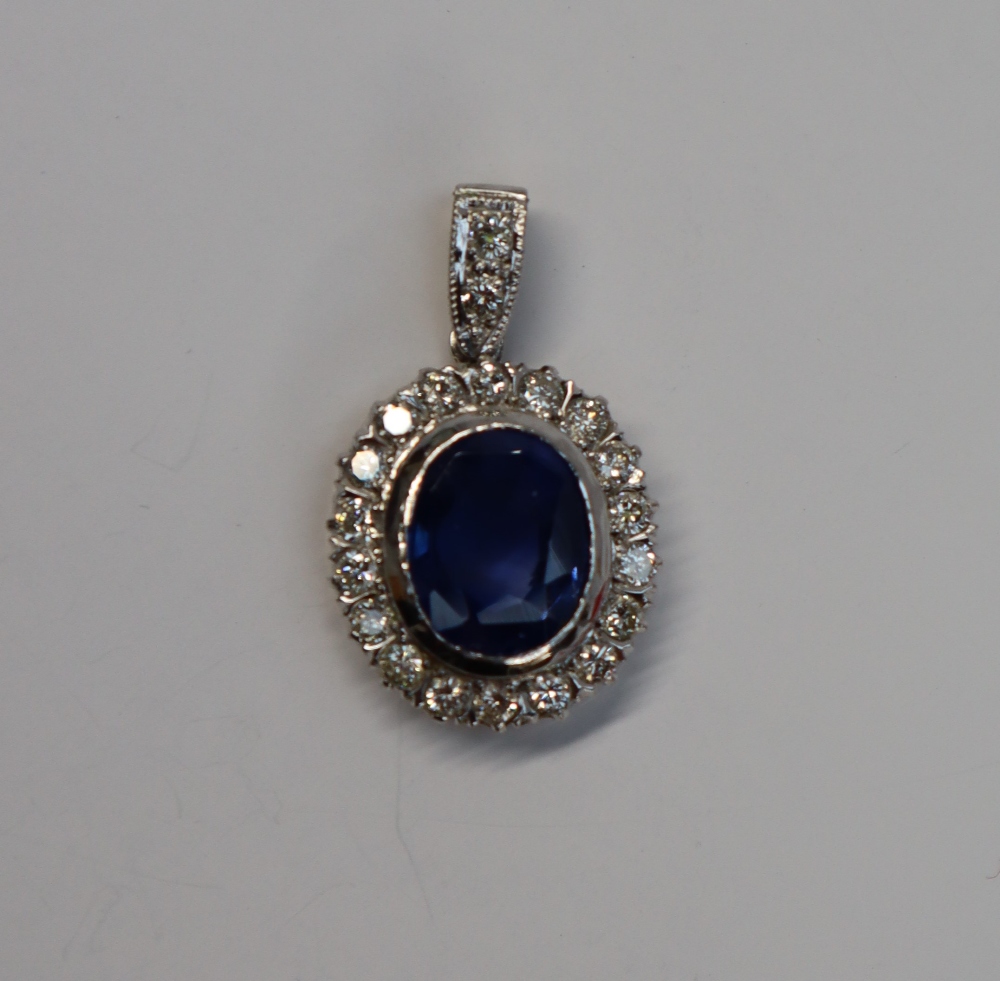 A cornflower blue sapphire and diamond cluster pendant,