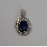 A cornflower blue sapphire and diamond cluster pendant,