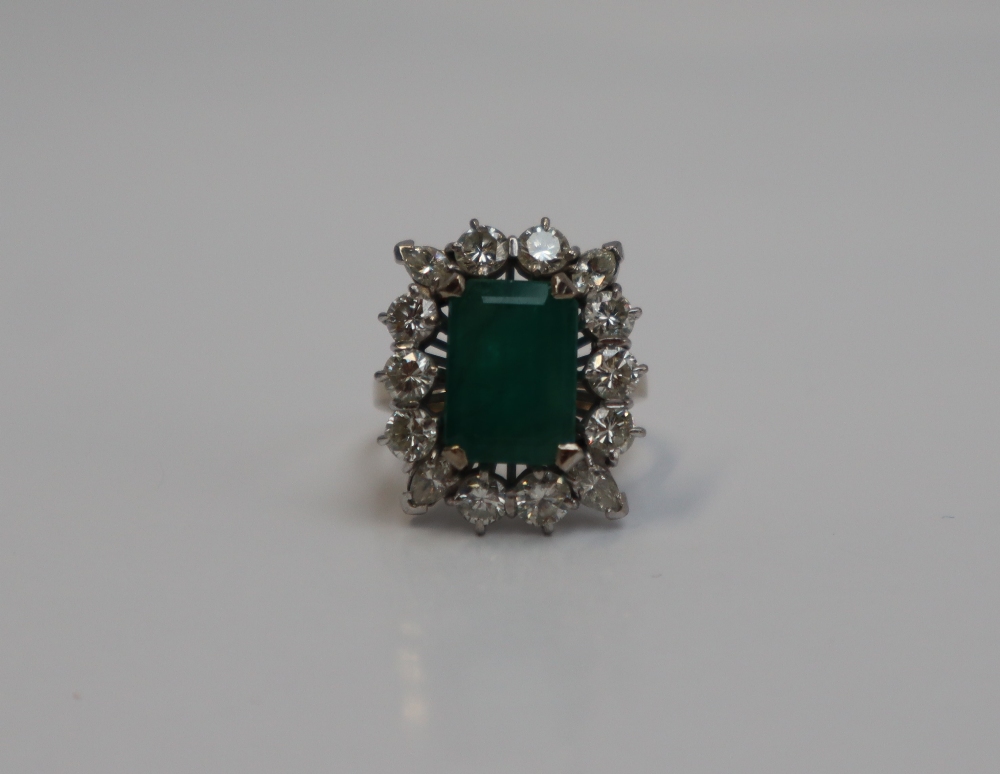 An emerald and diamond cluster ring, the central emerald cut emerald approximately 12mm x 9mm, - Image 7 of 7