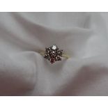 A diamond cluster ring set with seven round brilliant cut diamonds,