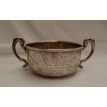 A George V silver twin handled sugar basin, with a line decorated top and scrolling handles,