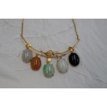 A Chinese yellow metal necklace set with jade and hard stone panels,